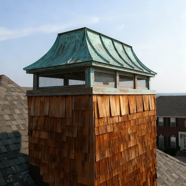 Patina copper louvered chimney cap on wooden structure